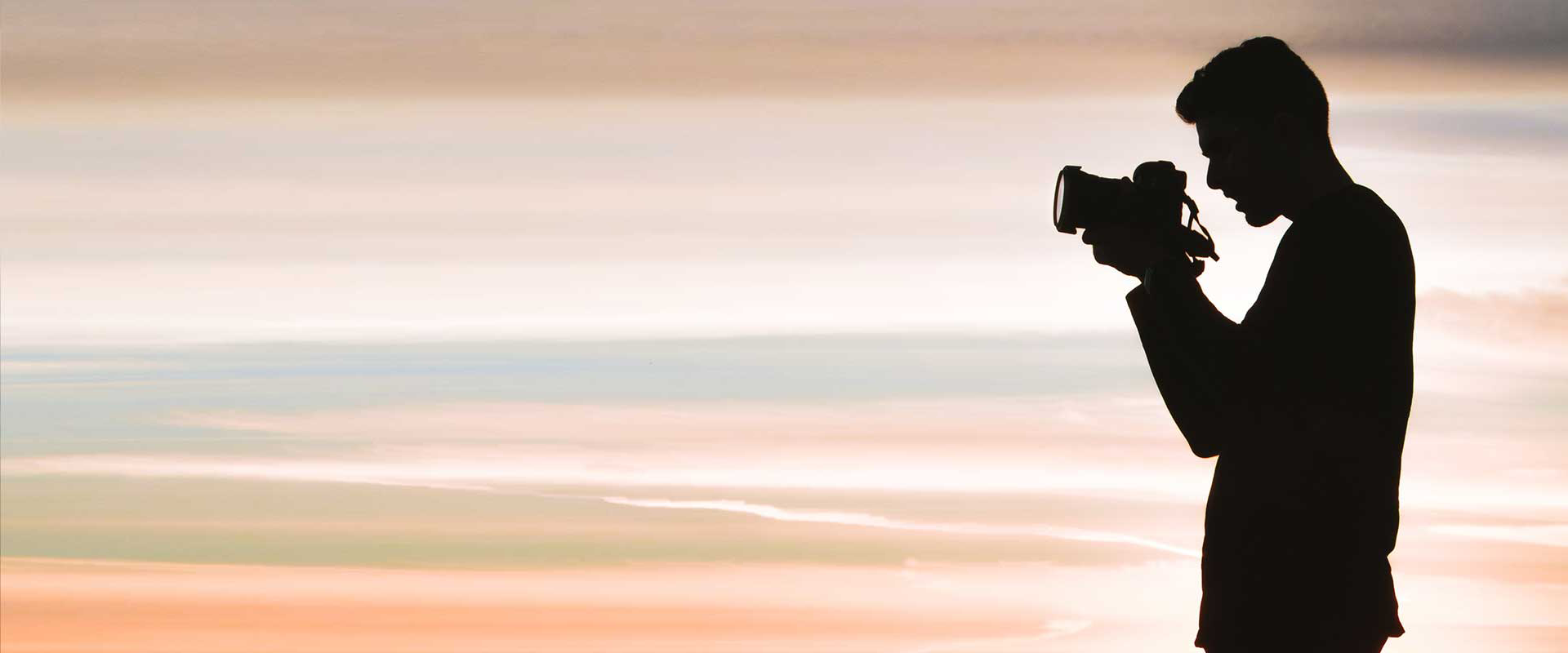 boy taking a photo in sunset